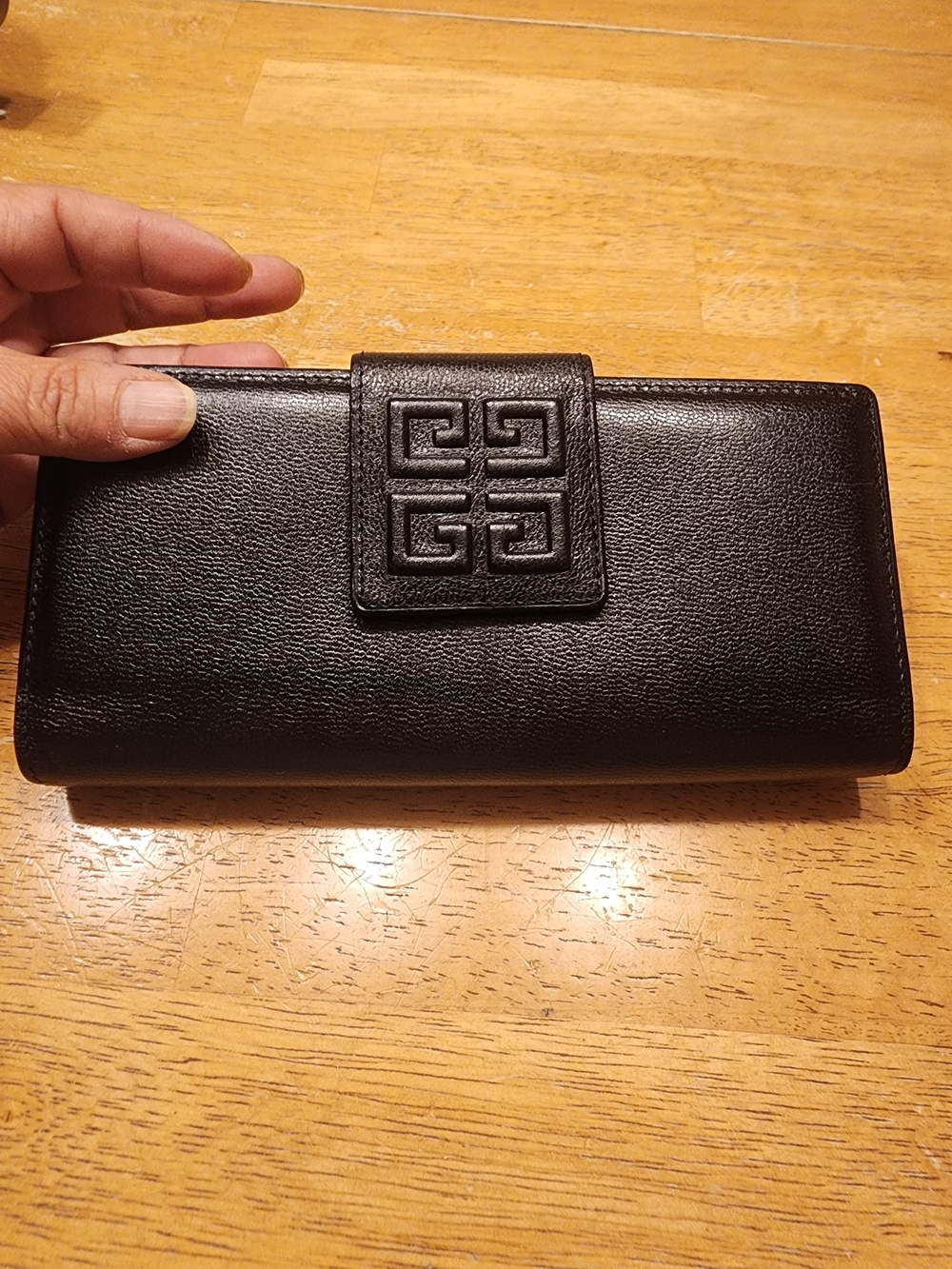 black leather Givenchy long wallet featuring a prominent embossed 4G logo
